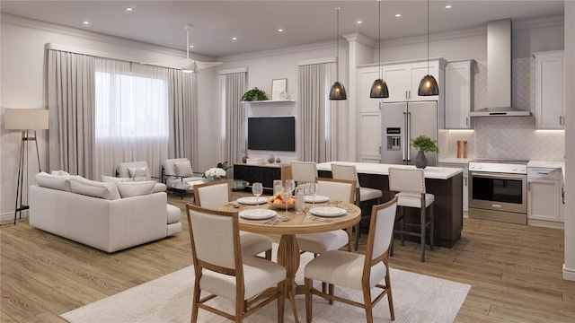 dining space featuring crown molding and light hardwood / wood-style floors