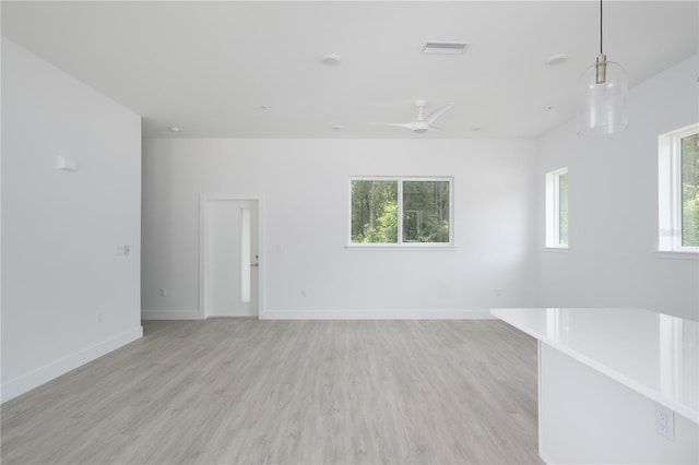 unfurnished living room with ceiling fan, light hardwood / wood-style flooring, and a healthy amount of sunlight