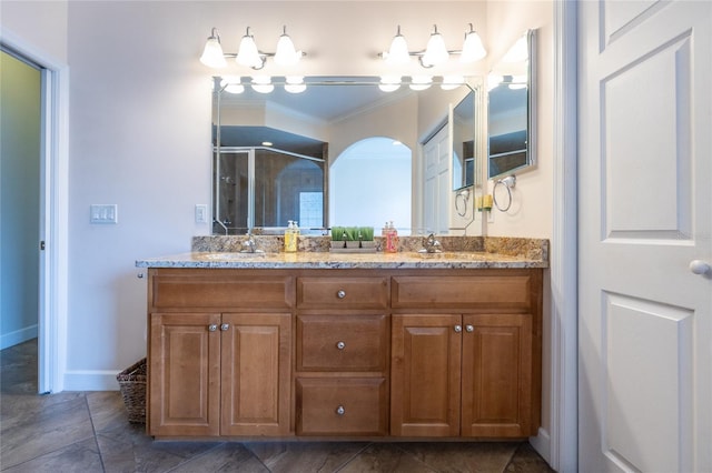 bathroom with tile patterned floors, crown molding, vanity, and walk in shower