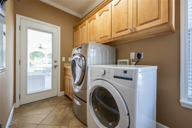 clothes washing area featuring cabinets, plenty of natural light, ornamental molding, and washing machine and clothes dryer