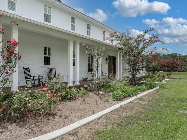 exterior space with covered porch and a front yard