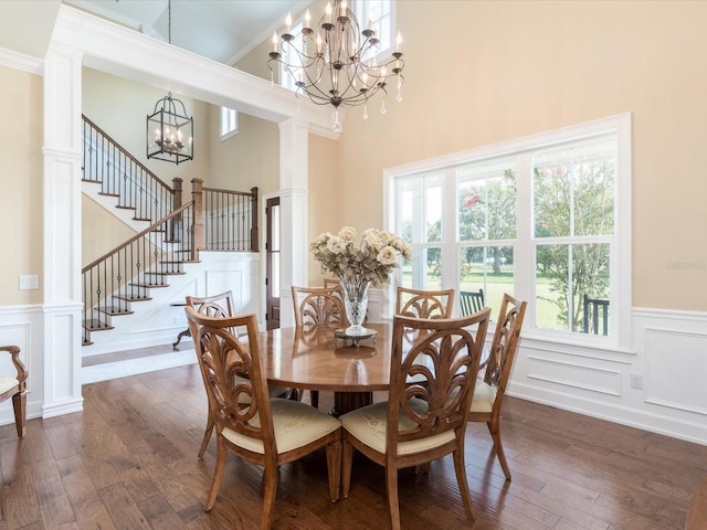 dining room featuring an inviting chandelier, dark hardwood / wood-style floors, a wealth of natural light, and a high ceiling