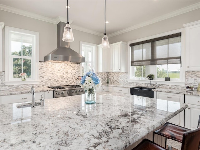 kitchen with tasteful backsplash, wall chimney exhaust hood, and a wealth of natural light