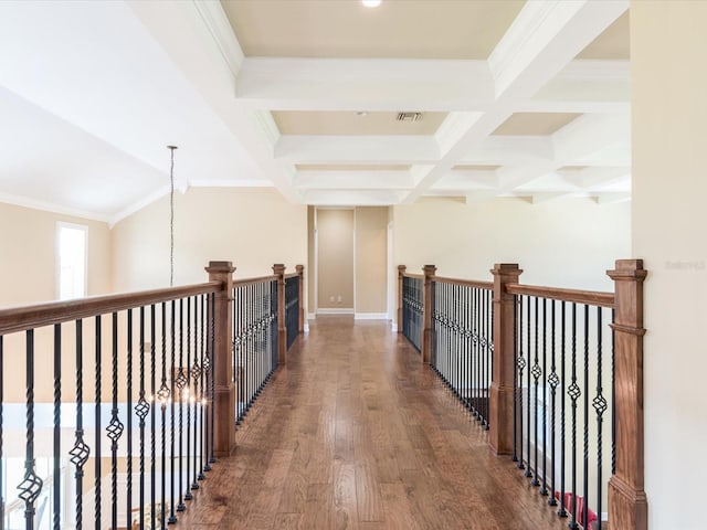 hallway with coffered ceiling, a chandelier, beamed ceiling, dark wood-type flooring, and crown molding