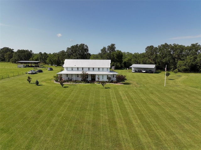 back of house with a yard and a rural view