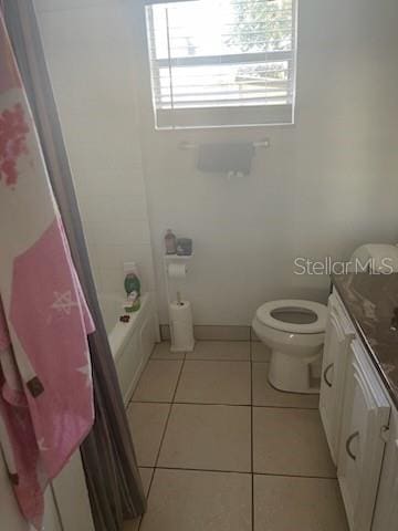 full bathroom with shower / bath combination with curtain, tile flooring, toilet, and vanity