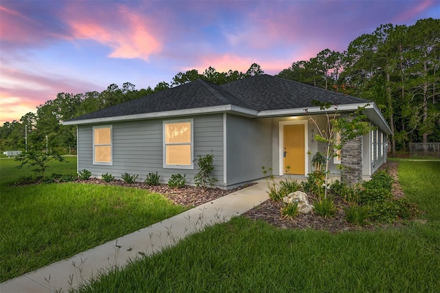 ranch-style home with a yard