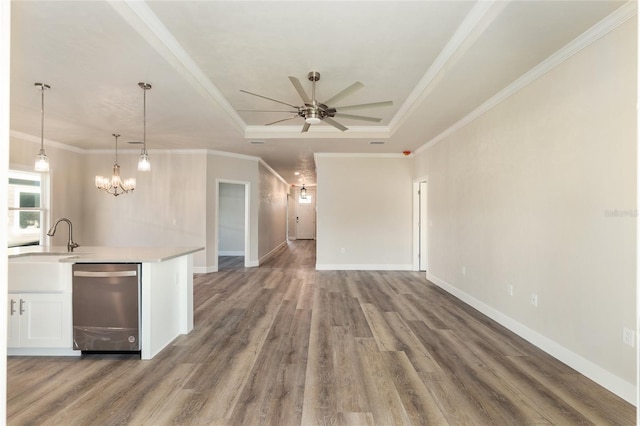 kitchen with white cabinetry, hanging light fixtures, ornamental molding, a tray ceiling, and hardwood / wood-style floors