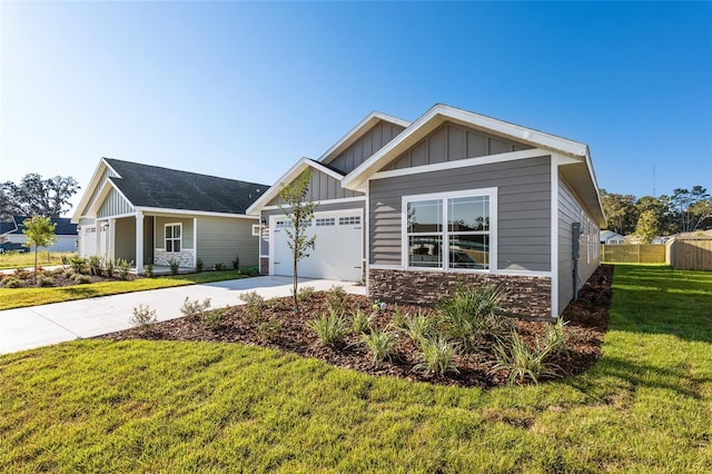 craftsman inspired home featuring a garage and a front lawn