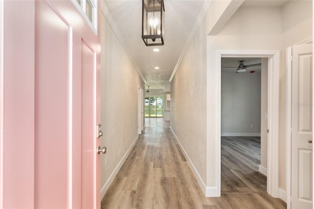 hallway featuring crown molding and light hardwood / wood-style floors