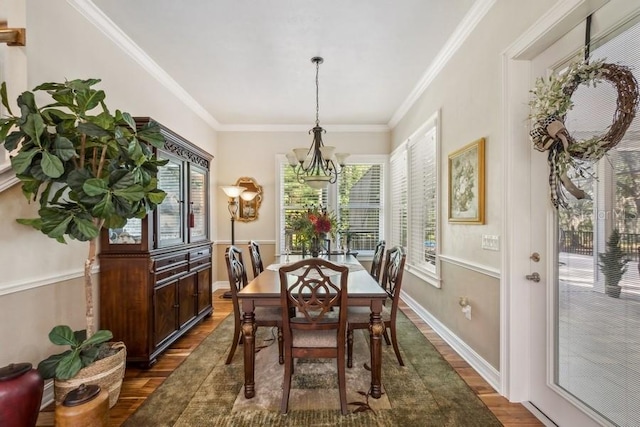 dining area with dark hardwood / wood-style flooring, a notable chandelier, and ornamental molding