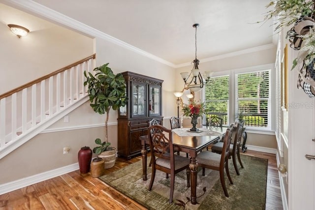 dining area with ornamental molding, an inviting chandelier, and dark hardwood / wood-style floors