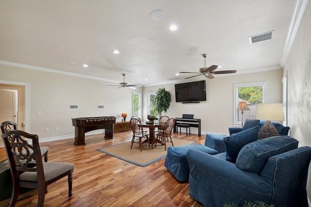 living room featuring ceiling fan, wood-type flooring, and ornamental molding