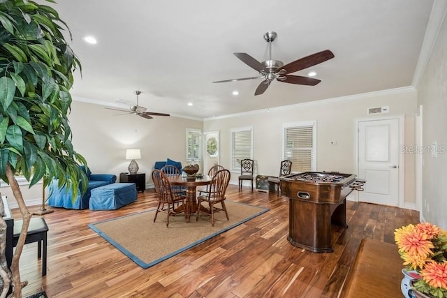 dining area with hardwood / wood-style flooring, crown molding, and ceiling fan