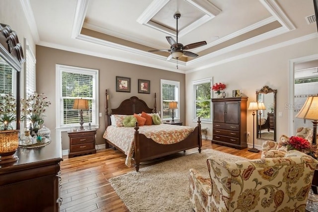 bedroom featuring ceiling fan, multiple windows, light wood-type flooring, and crown molding