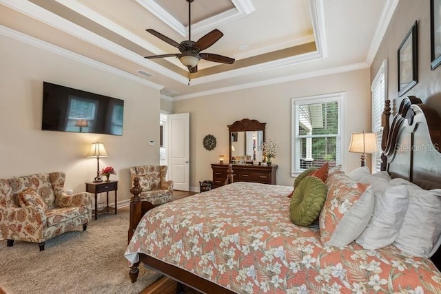 bedroom with ceiling fan, ornamental molding, carpet flooring, and a tray ceiling