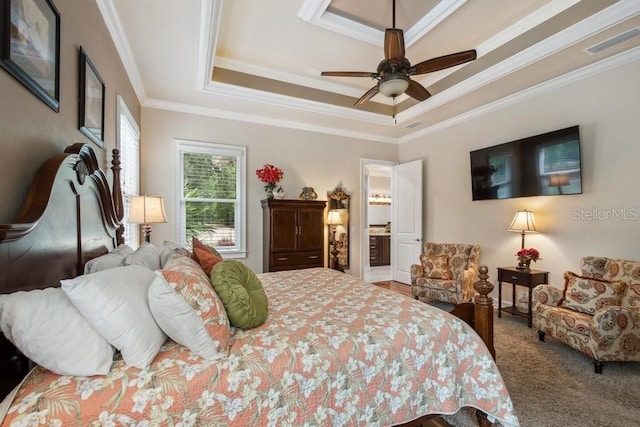 bedroom with ceiling fan, a tray ceiling, and ornamental molding