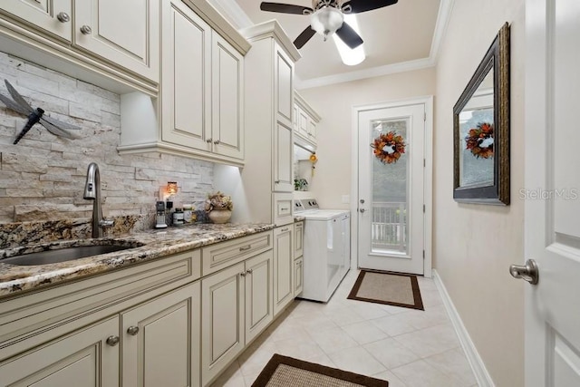 laundry area featuring cabinets, sink, ornamental molding, light tile patterned floors, and independent washer and dryer