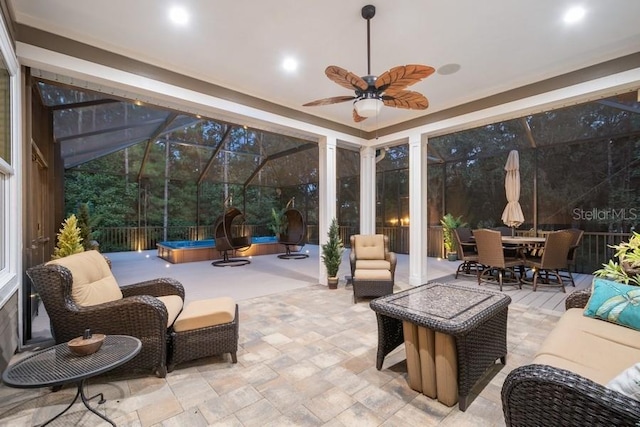 view of patio / terrace featuring glass enclosure, ceiling fan, and an outdoor living space