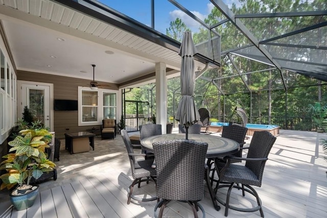 deck featuring a patio, glass enclosure, and ceiling fan