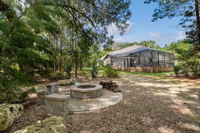 view of yard featuring a fire pit and glass enclosure