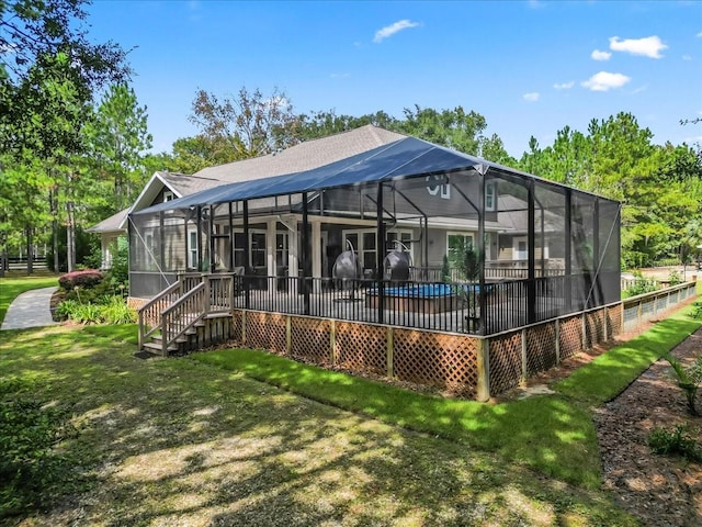 rear view of house featuring glass enclosure, a patio, and a yard