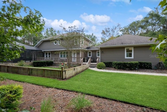 back of house featuring a lanai, a yard, and a deck