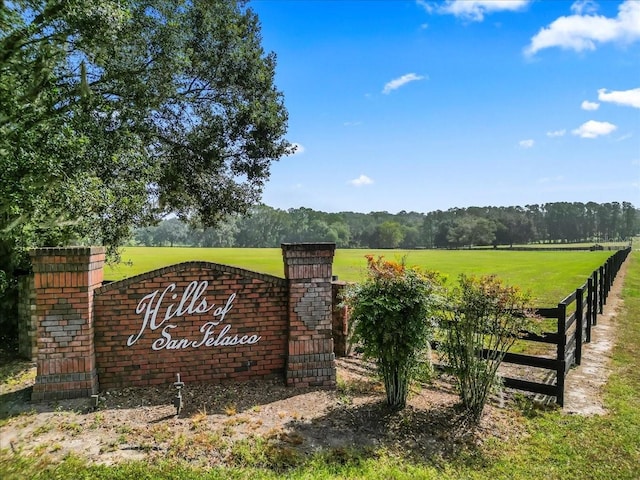 community sign featuring a yard and a rural view