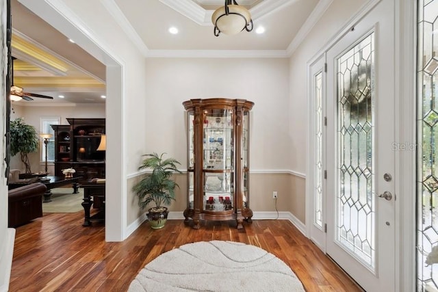 foyer featuring hardwood / wood-style floors, ceiling fan, and ornamental molding