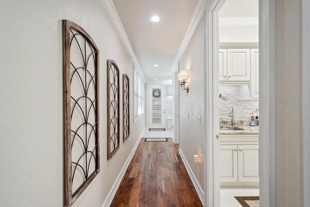 hall featuring sink, hardwood / wood-style flooring, and ornamental molding