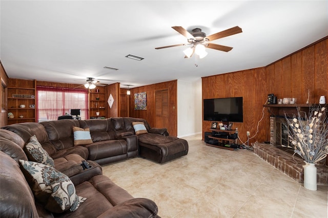 living room with ceiling fan, wooden walls, and a fireplace