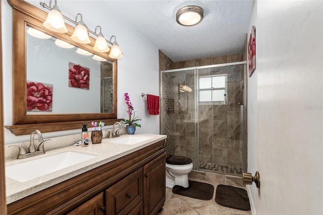 bathroom featuring a textured ceiling, an enclosed shower, vanity, and toilet