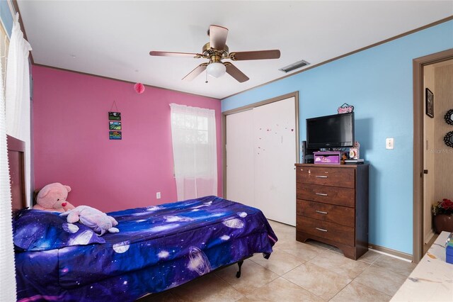 bedroom featuring ceiling fan, a closet, and light tile patterned floors