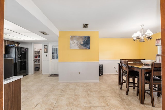 dining space with light tile patterned floors and a chandelier