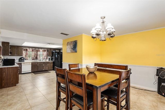 dining space with light tile patterned floors, sink, and a chandelier