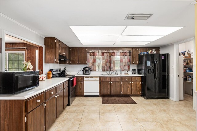 kitchen featuring light tile patterned flooring, crown molding, black appliances, dark brown cabinetry, and sink