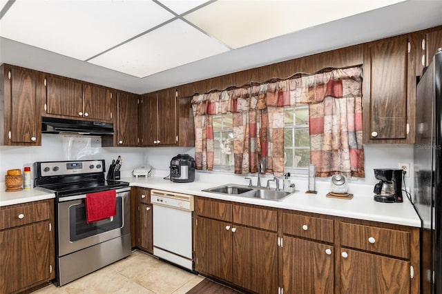 kitchen featuring dark brown cabinets, appliances with stainless steel finishes, light tile patterned flooring, and sink