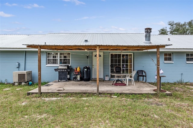 rear view of house with a lawn and a patio