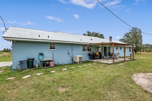 rear view of house with a yard and a patio