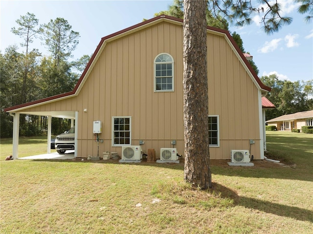 back of property with a lawn, central AC, and a carport