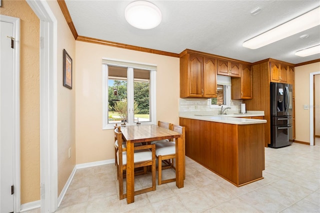 kitchen with stainless steel fridge with ice dispenser, light tile flooring, backsplash, and crown molding