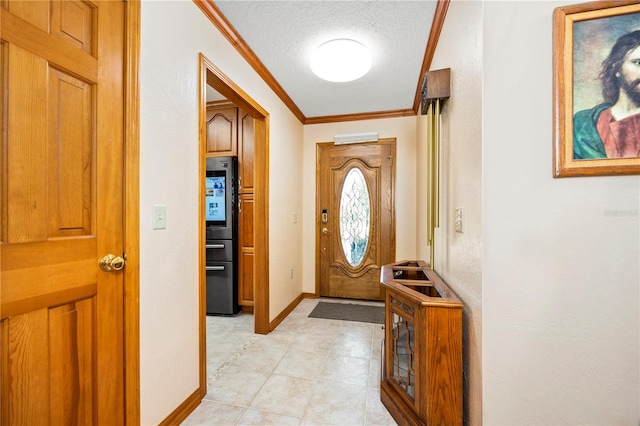 tiled foyer entrance featuring a textured ceiling and ornamental molding