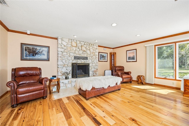 living room with ornamental molding, light hardwood / wood-style flooring, and a fireplace