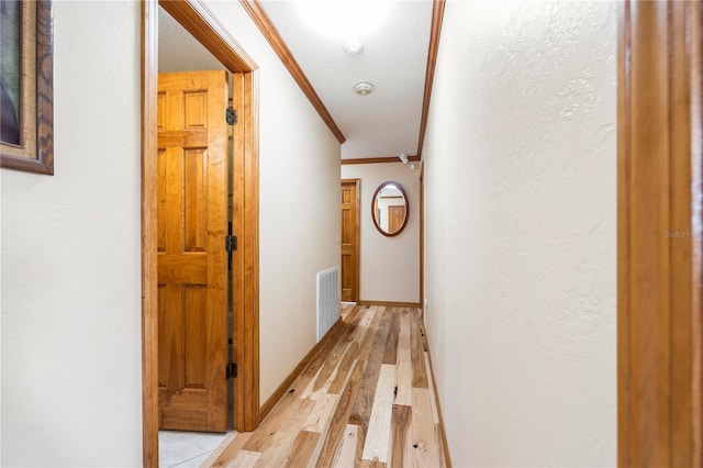 hall featuring crown molding and light wood-type flooring