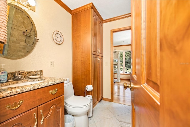 bathroom with toilet, tile flooring, vanity, and crown molding