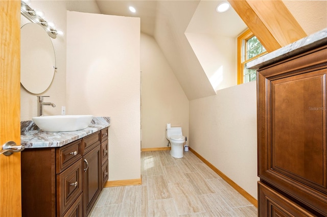 bathroom featuring toilet, large vanity, vaulted ceiling, and tile flooring