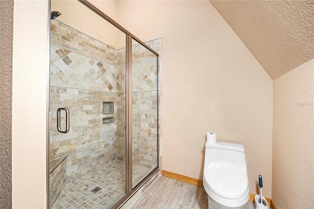 bathroom with an enclosed shower, a textured ceiling, toilet, and vaulted ceiling