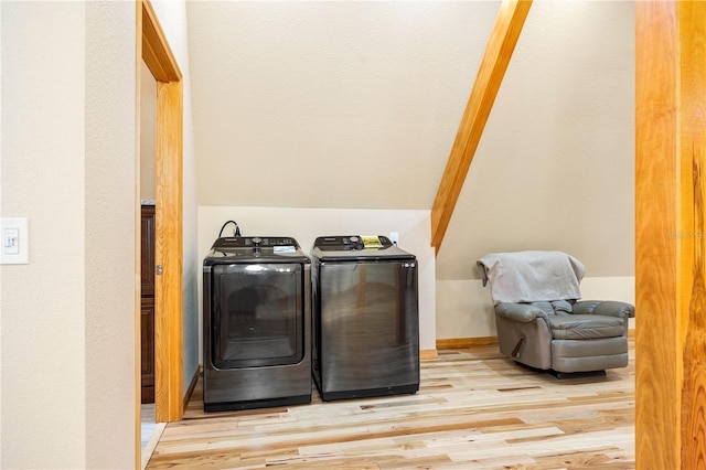 washroom with separate washer and dryer and light hardwood / wood-style flooring