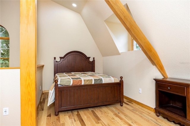 bedroom with multiple windows, light hardwood / wood-style floors, and vaulted ceiling