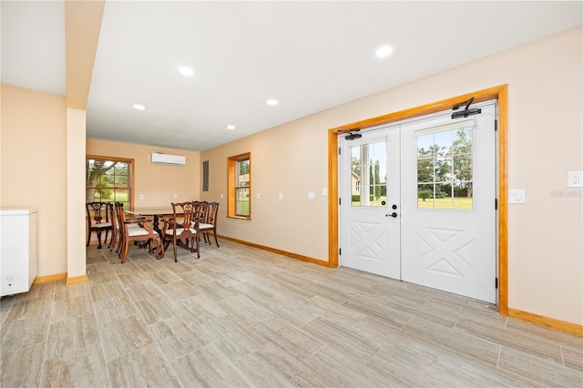 dining room with french doors, a healthy amount of sunlight, and a wall unit AC